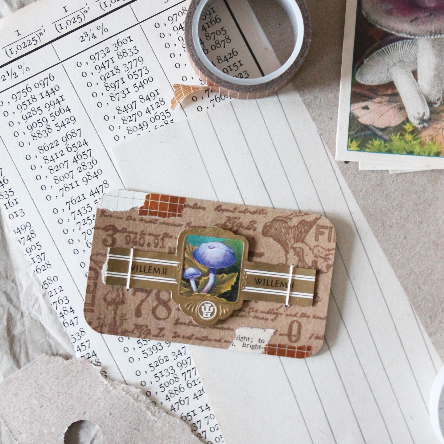 Oude sigarenbandjes zijn soms net schilderijtjes. Ze laten zich mooi verwerken in collages. Dit bundeltje paddenstoelen gaat mee als cadeautje bij een brief. Ik bestempelde een kaartje van kraft papier en prikte er met een naald vier gaatjes in, om een touwtje doorheen te halen. Die strik je aan de achterzijde makkelijk vast. Zo maak je simpel en snel een handgemaakte verpakking voor kleine papierwaren 🏷